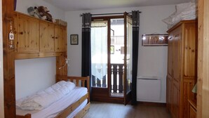 Une petite pièce agréable, dotée d’un lit superposé, de meubles en bois et d’un radiateur.
