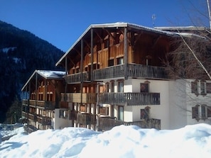 Un chalet in legno con numerosi balconi e un paesaggio innevato.