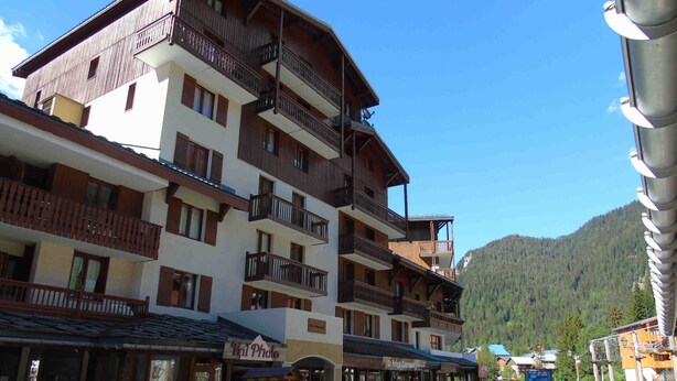 A multi-story hotel with balconies and a mountain backdrop. - Cozy 2-Room Mezzanine Apartment for 4, Steps from Lift & Shops in Valfréjus (Valfréjus)