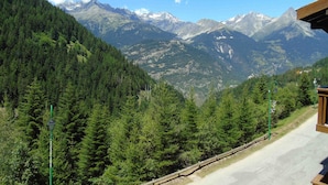 A mountain landscape with a road and a building with a wooden roof. - Cozy 2-Room Mezzanine Apartment for 4, Steps from Lift & Shops in Valfréjus (Valfréjus)