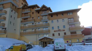 A multi-story hotel with balconies and a sign reading "Le Cheval Blanc". - Cozy 2-Room Apartment - Ski-In/Ski-Out, Balcony, Pet-Friendly, Sleeps 6 (Valfréjus)