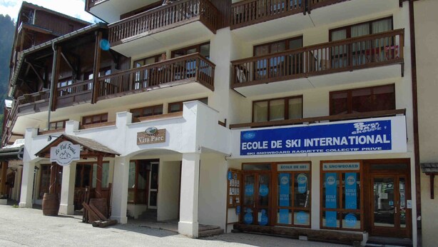 A multi-story building with a ski school named 'Ecole de Ski International' and a restaurant named 'Le Pal Frus'. - Cozy Studio for 4 near Ski Lifts and Shops, Includes Linens, Kitchen, Balcony with Scenic Views (Valfréjus)