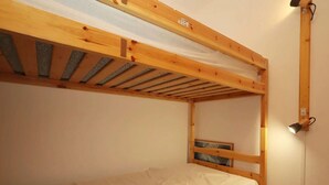 A bunk bed with a wooden frame and a mattress.