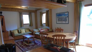 A cozy living room with a wooden dining table, two sofas, and a coffee table.