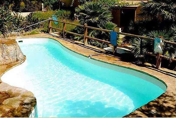 A swimming pool with a wooden deck and a metal railing. - Apartment- Bilocale - One Bedroom Apartment, Sleeps 2 (Favignana)