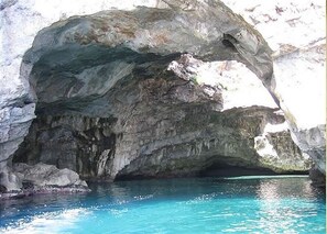 A natural rock formation with a clear blue pool at its base. - Apartment- Bilocale - One Bedroom Apartment, Sleeps 2 (Favignana)