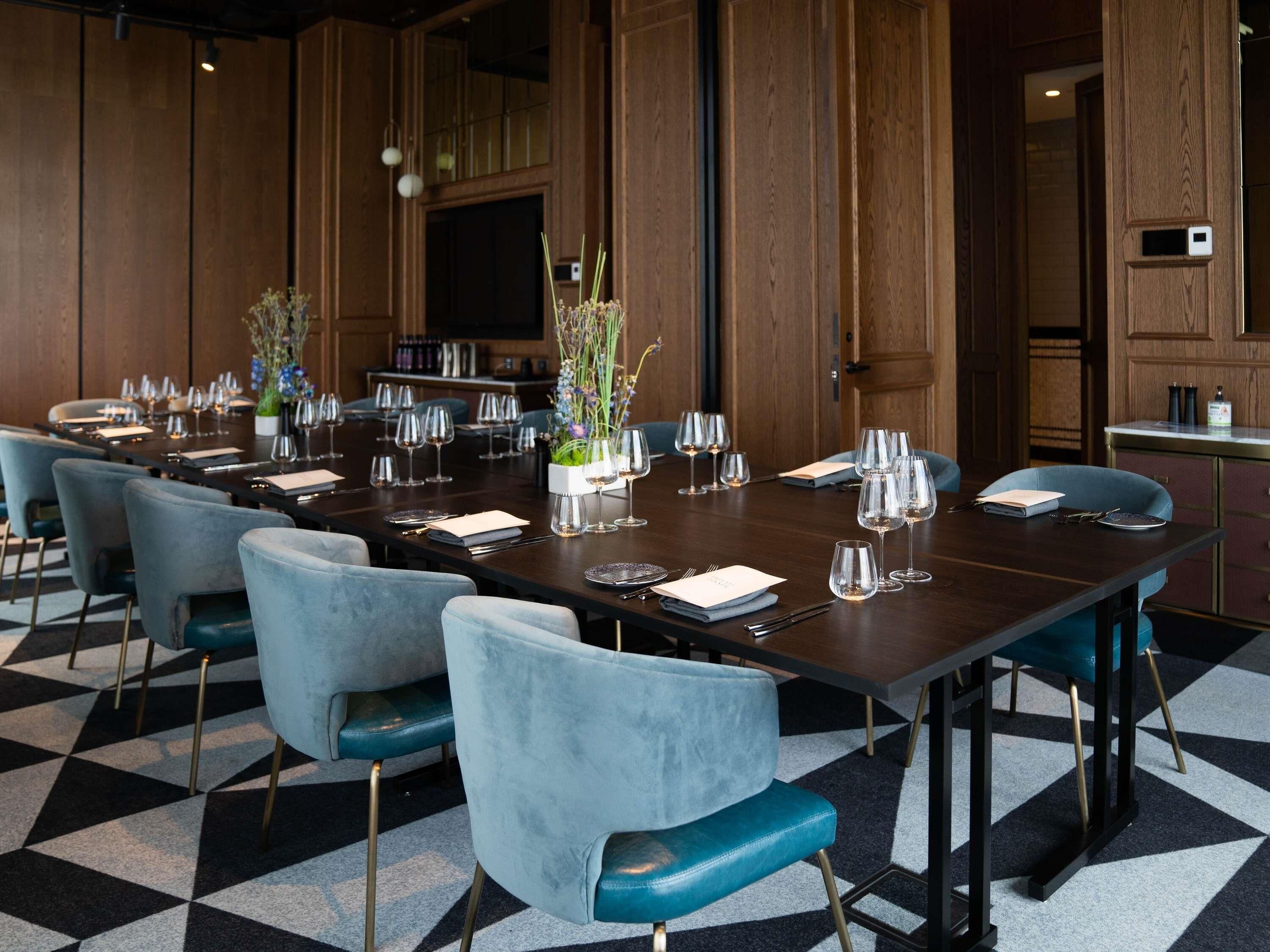 A conference room with a long table, multiple chairs, and a small plant centerpiece.