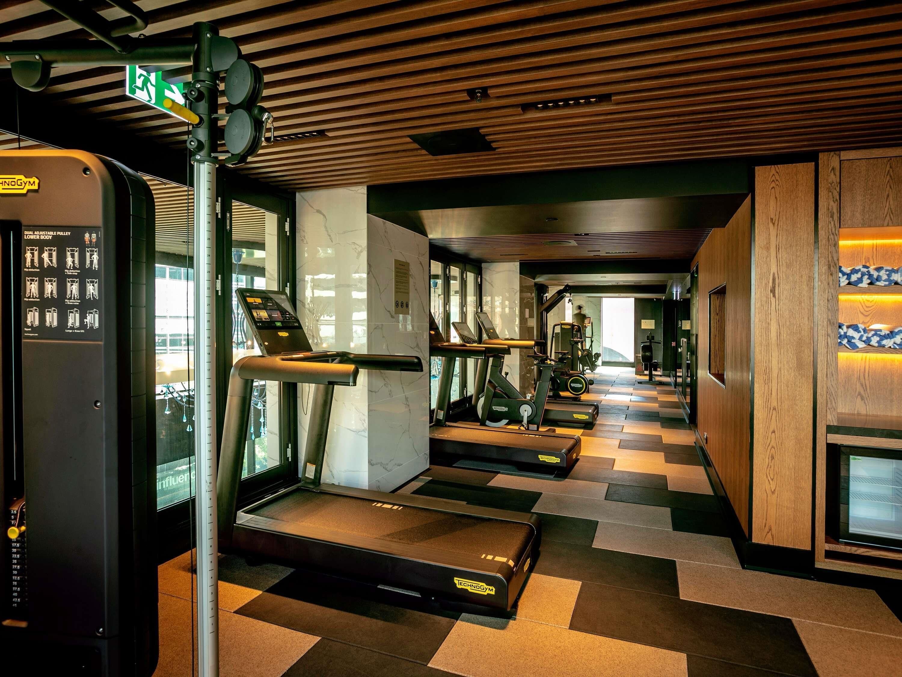 Een sportschool met loopbanden, trainingsfietsen en een digitale kiosk.