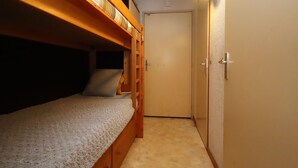 A bunk bed room with a door and a light fixture.