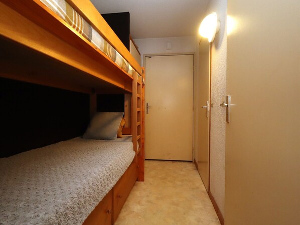 A bunk bed room with a door and a light fixture.