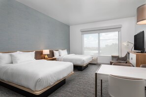 A hotel room with two beds, a desk, a chair, a television, and a large window. - TownePlace Suites by Marriott® Orlando Near Universal (Orlando)