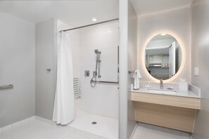 A modern bathroom with a shower, a vanity with a mirror, and a toilet. - TownePlace Suites by Marriott® Orlando Near Universal (Orlando)