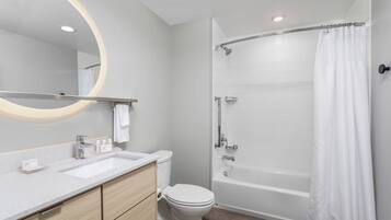 A modern bathroom with a vanity, toilet, and a walk-in shower.