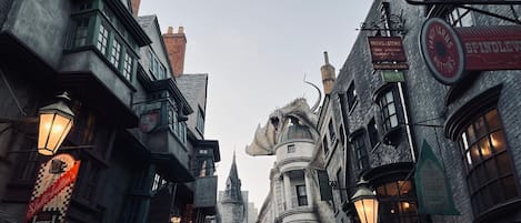 A narrow street with traditional architecture, including a shop with a sign that reads "Spindle & Sons."