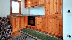 A kitchen with wooden cabinets, a built-in oven, and a window.