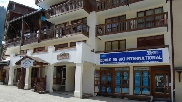 A building with a sign for 'Ecole de Ski International' and another sign for 'Viva Parc'. - Charming studio for 4 near slopes with balcony, pets allowed (Valfréjus)