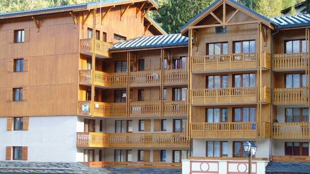 A multi-story wooden building with balconies, a stone facade, and a sign for a boutique. - Cozy studio 4 ppl, near gondola & shops (Valfr éjus)