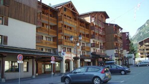 A multi-story building with balconies, a no parking sign, and a car parked on the street. - Cozy studio 4 ppl, near gondola & shops (Valfréjus)