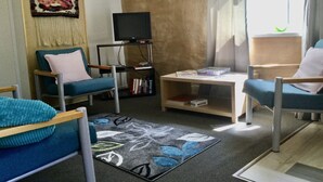 A living room with a television, books, and a coffee table.