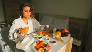 A person sitting at a breakfast table with a variety of food items including fruits, pastries, and beverages. - Jewel Maadi Cabins and Club (Cairo)