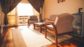 A living room with a sofa, armchairs, a coffee table, and a refrigerator. - Jewel Maadi Cabins and Club (Cairo)