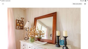 A room with a wooden dresser, a mirror, a vase with dried flowers, and two candle holders. - Cozy confortable (Pulaski)