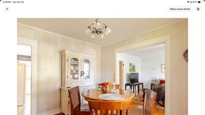 A dining area with a wooden table and chairs, a chandelier, and a cabinet with glass doors. - Cozy confortable (Pulaski)