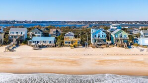 A beachfront property with multiple houses, a sandy beach, and a view of the ocean. - Vintage Vacation Pet Friendly, Ocean Views! (Surf City)
