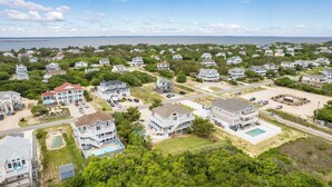 Un área residencial costera con casas, una playa y vistas al mar.