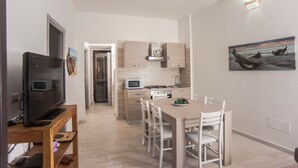 Una cucina moderna con zona pranzo, televisione e un quadro appeso al muro.
