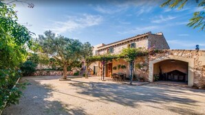 A stone building with a courtyard, outdoor seating, and a covered area. - Beautiful Country Home “Son Vanrell” with Mountain View, Pool, Wi-Fi, A/C, Terrace & Garden; (Campos)