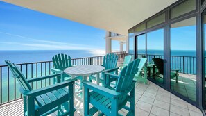 Enjoy the ocean view from this balcony with a comfortable seating area featuring four Adirondack chairs and a small table.