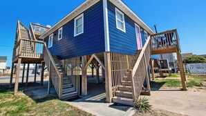 A two-story house with a wooden deck and a staircase leading to a second-story balcony. - Semi-Oceanfront, 100 ft to beach access, Sun Decks, KH141, Blue Heaven (Kitty Hawk)