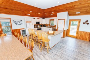 A modern kitchen with a central island, wooden chairs, and a dining table. - Soundfront, Sound views, Private Pool, Hot Tub! 509, Friday Harbor (Corolla)