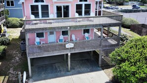 A two-story house with a balcony, a garage, and a visible driveway. - Oceanside, Dogs Welcome, Private Pool, Hot Tub, Close to Beach Access, OL626, Celtic Dunes (Corolla)