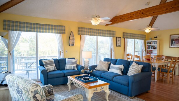 A living room with a blue sofa set, a wooden coffee table, and a patterned armchair.
