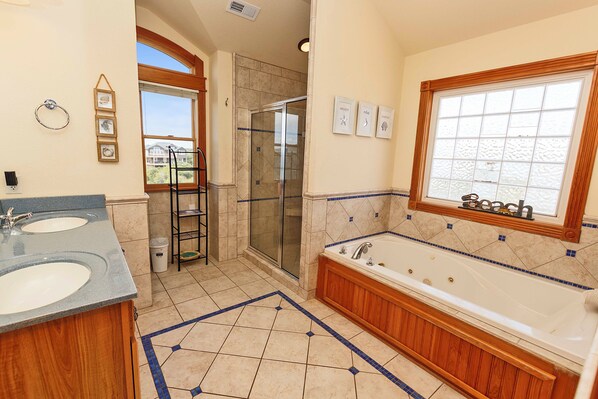 A bathroom with two sinks, a shower, and a bathtub.
