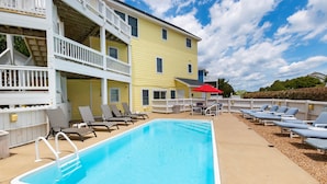 A pool area with lounge chairs and a red umbrella. - Oceanside, Heated Pool, Poolside Pavilion, Hot Tub, 4, Relax Mom (Corolla)