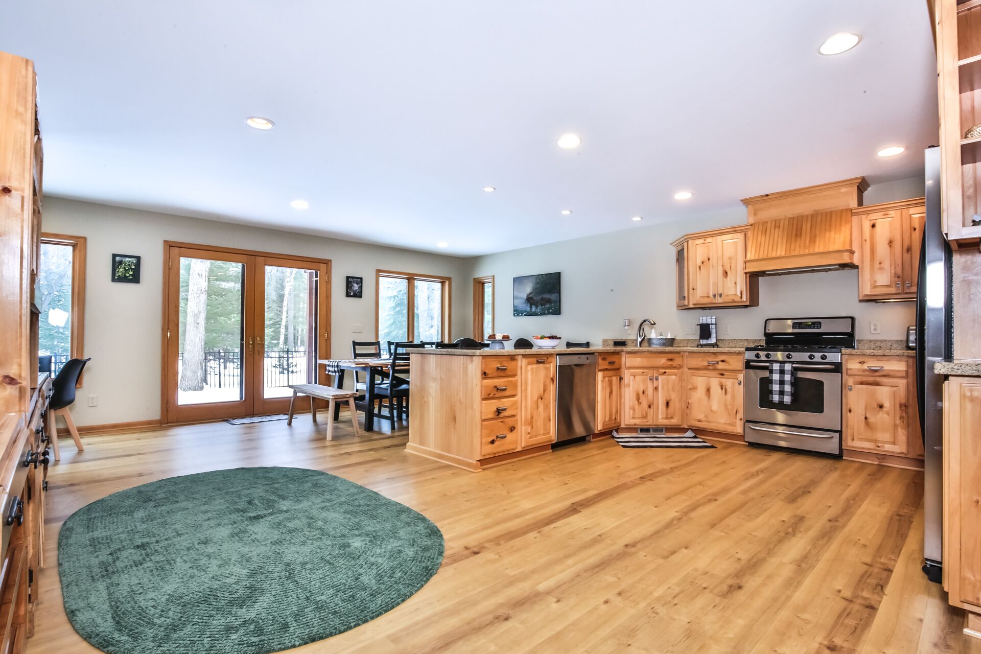 A modern kitchen with wooden cabinets, stainless steel appliances, and a large island.
