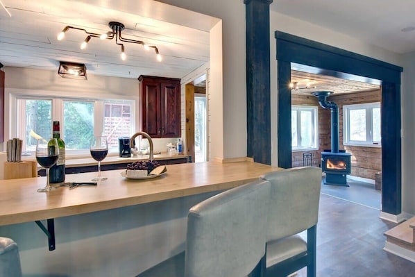 A modern kitchen with a central island, wooden cabinets, and a large window.