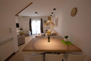 Enjoy meals in a spacious dining area with a wooden table and comfortable seating.