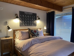 Cozy retreat with a phonetic alphabet wall, comfortable bed, and functional nightstand.