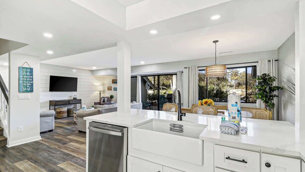 A modern kitchen with a dishwasher, white cabinets, and a large island with a sink. - Inverness Villa on Golf Course with Pool & Tennis (Hilton Head Island)