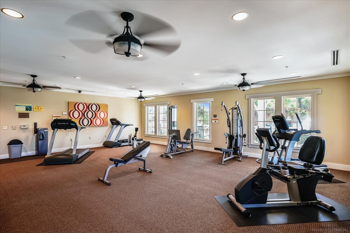 Ein Fitnessstudio mit Laufbändern, Crosstrainern und Kurzhanteln.