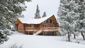 A log cabin with a wooden deck and a staircase leading to a second level. - PRICES REDUCED !  Luxury upscale cabin, quiet cul-de-sac, free Wi-Fi (Duck Creek Village)