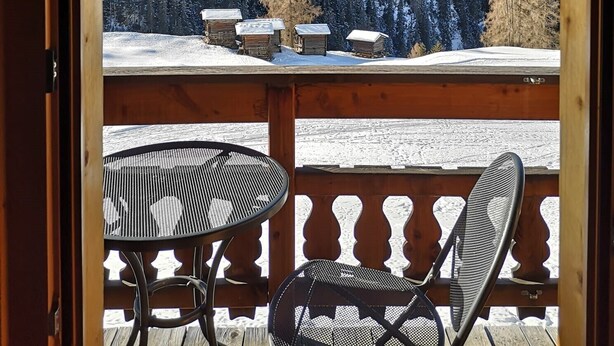 A balcony with a view of a snowy mountain landscape.