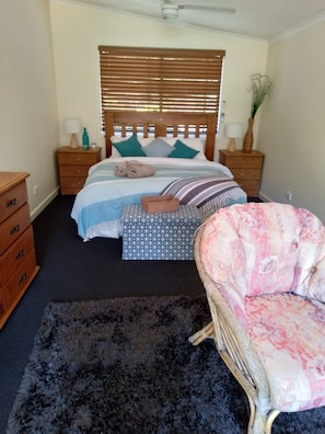 Cozy retreat with a large bed, bedside table, and plush rug.
