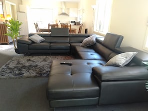 Relax in this stylish living room with a comfortable sofa, matching ottoman, and dining area.
