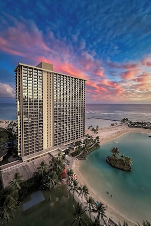 A high-rise hotel with a pool, beach, and ocean view.