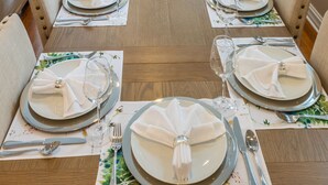 A formal dining room with a long wooden table set for a meal, surrounded by upholstered chairs. - NEW LUXURY PENTHOUSE CONDO (Chicago)